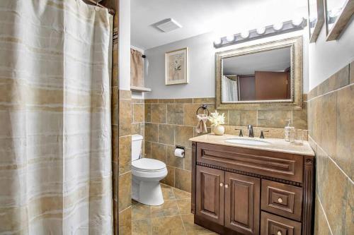 uma casa de banho com um lavatório, um WC e um espelho. em Welcome to our Cozy Krib em Buffalo