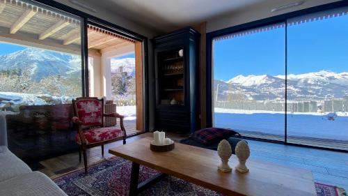 uma sala de estar com vista para as montanhas cobertas de neve em Le Chalet de Castille - chalet pyrénéen grand confort - spa em Beaucens