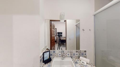 uma casa de banho com um lavatório e um espelho em Studio 7 Pinheiros by Oba em São Paulo