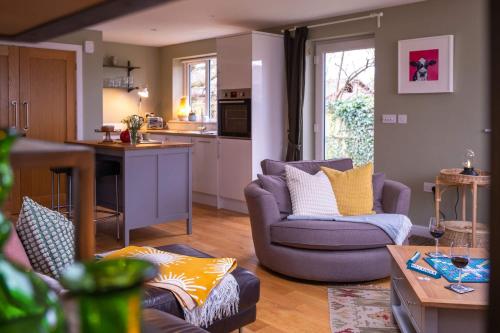 a living room with two couches and a kitchen at The Nest in Brockenhurst