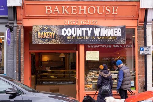 a couple of people walking in front of a bakery at The Nest in Brockenhurst