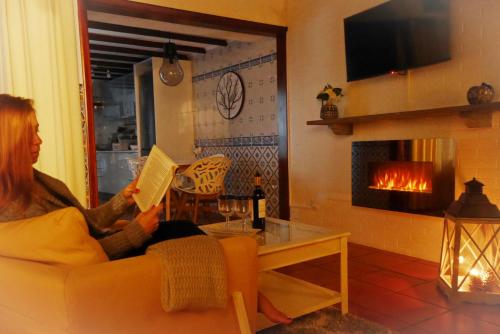 a woman sitting on a couch reading a book at Furnas Nook in Furnas
