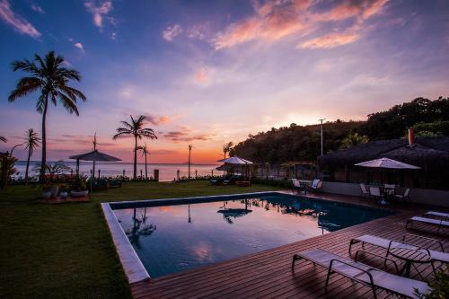 a swimming pool with a view of the ocean at sunset at Residencial Marina Del Sol in Pauba