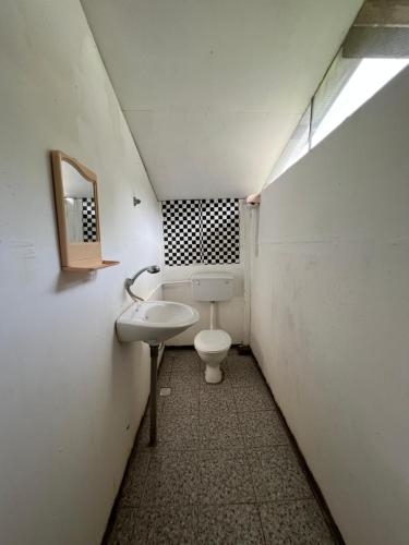 a small bathroom with a toilet and a sink at Mulu Village in Mulu