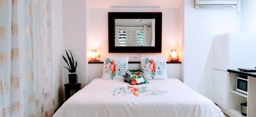 a bedroom with a bed with white sheets and a mirror at EVASION Bungalow Tropical Spa in Sarraméa