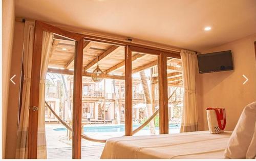 1 dormitorio con 1 cama y puerta corredera de cristal en Hotel Nude Zipolite & beach club, en Zipolite
