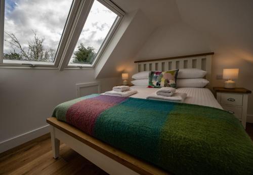 a bedroom with a bed with a colorful blanket on it at The Barn in Fort William