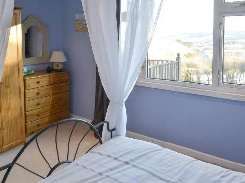 a bedroom with a bed and a window with a view at Rowan Cottage-80119 in Catcleugh