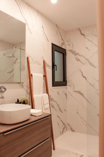 a bathroom with a sink and a mirror at Fornas House in Caminha