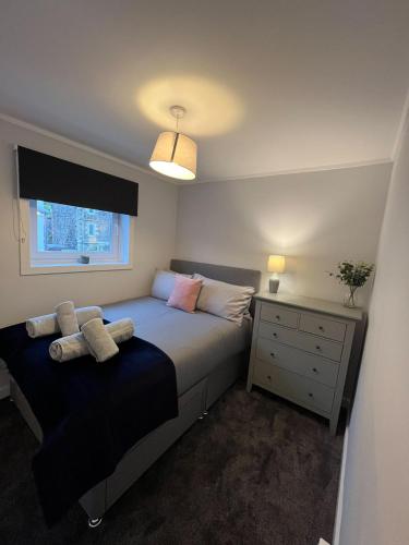 une chambre avec un lit, une commode et une fenêtre dans l'établissement Breadalbane Apartment, à Oban