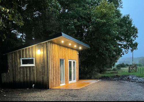 ein kleines Holzgebäude mit Licht in der Unterkunft Lora Cabin in Oban