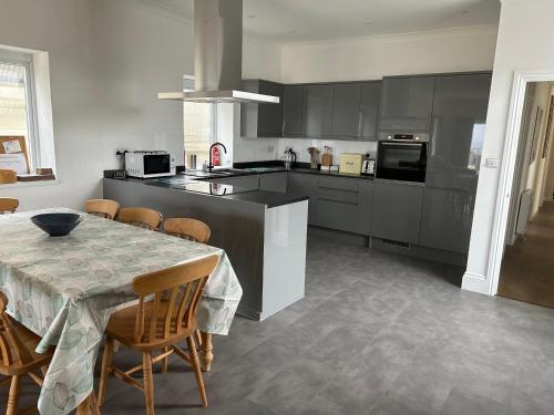 eine Küche mit einem Tisch und Stühlen sowie eine Küche mit einem Tisch und einem Tisch in der Unterkunft Treleigh in Hayle