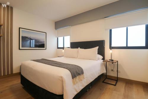 - une chambre avec un grand lit et 2 fenêtres dans l'établissement Picturesque 2BR in Miraflores, à Lima