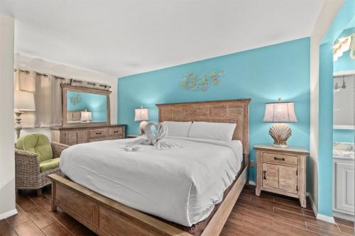 a bedroom with a large white bed and blue walls at The Summit 731 in Panama City Beach