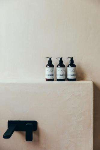 three bottles of soap sitting on a shelf at Cucu Hotel El Cuyo in El Cuyo