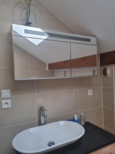 une salle de bain avec un lavabo et un miroir dans l'établissement Vue magique, à Sallanches