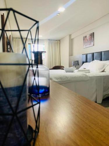 a room with a bed and a bottle on a table at BEACH CLASS EXECUTIVE apto 206 in Recife