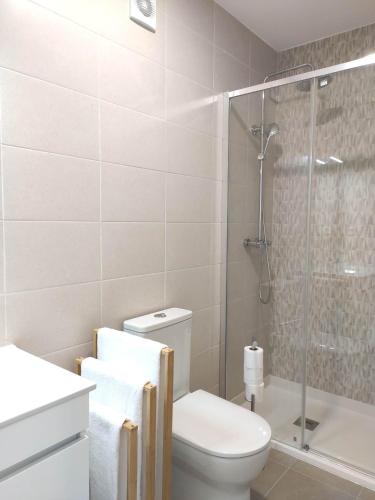 a bathroom with a toilet and a glass shower at Aveiro Ria House in Aveiro
