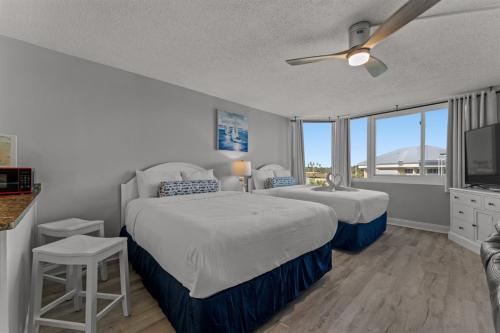 a bedroom with two beds and a flat screen tv at Top of The Gulf 306 in Panama City Beach
