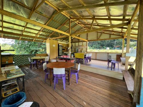 Habitación con mesa, sillas y suelo de madera. en Mulu Village, en Mulu