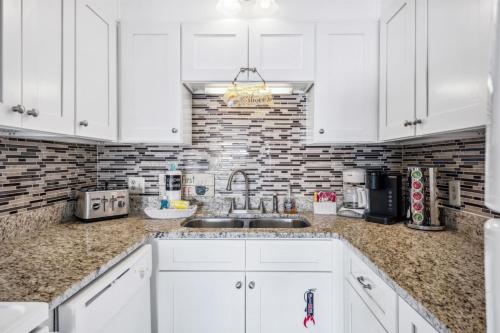 a kitchen with white cabinets and a sink at The Summit 307 in Panama City Beach