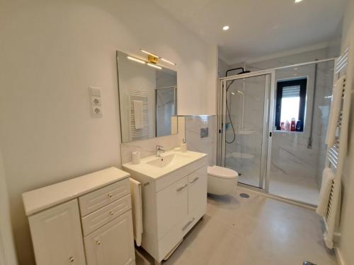 a white bathroom with a sink and a shower at Appartement 4 pièces in Ponte de Lima
