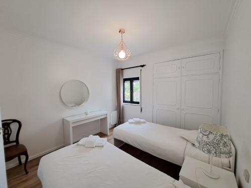 1 dormitorio con 2 camas, silla y espejo en Appartement 4 pièces, en Ponte de Lima