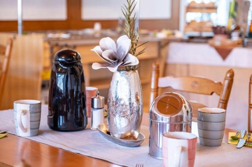 a table with a vase with a flower in it at Mike‘s Mosel Lodge in Treis-Karden