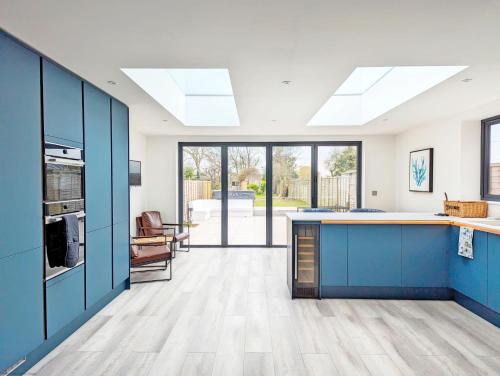 a kitchen with blue cabinets and a counter top at Malthouse Cottage in West Wittering
