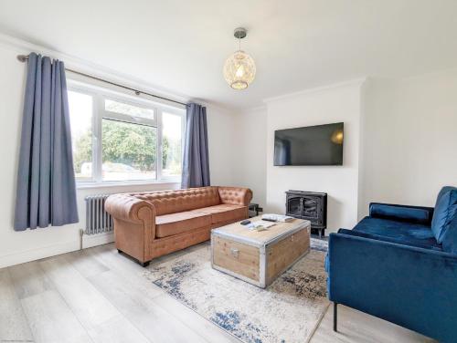 a living room with a couch and a table at Malthouse Cottage in West Wittering