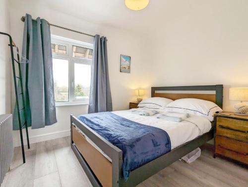 a bedroom with a large bed and a window at Malthouse Cottage in West Wittering