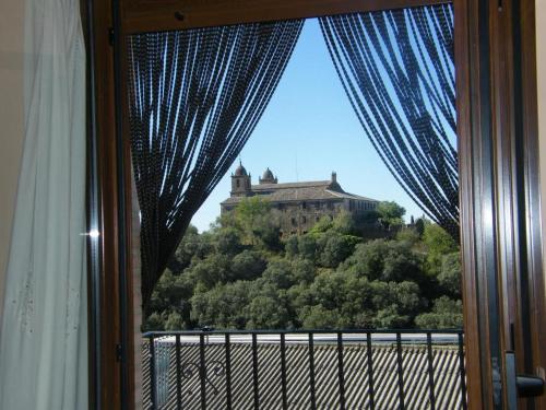 a window with a view of a castle on a hill at CASA JESUS in Abiego