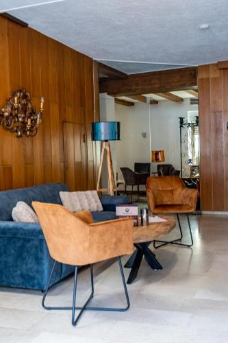 a living room with a blue couch and chairs at Mike‘s Mosel Lodge in Treis-Karden