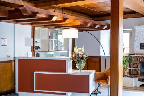 a lobby with a table and a vase of flowers at Mike‘s Mosel Lodge in Treis-Karden