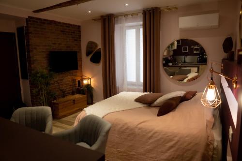 um quarto com uma cama com um espelho e uma cadeira em Studio cœur de ville sanary très cosy parking em Sanary-sur-Mer