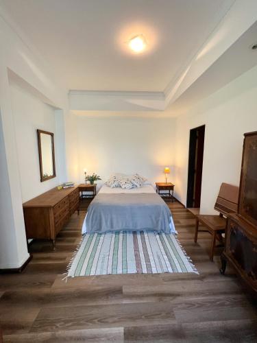 a bedroom with a bed and two tables and a dresser at Casa 9 de julio in Tandil