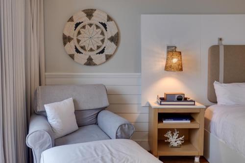 a room with a chair and a bed and a clock at Ashore Resort & Beach Club in Ocean City