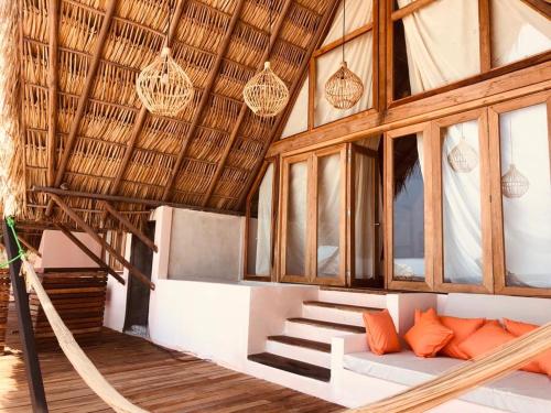 a room with a hammock in a house with windows at Hotel Nude Zipolite & beach club in Zipolite