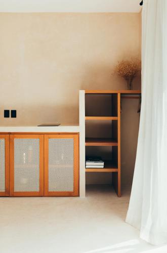 a room with a book shelf and a curtain at Cucu Hotel El Cuyo in El Cuyo