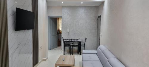 a living room with a white couch and a table at Bel appartement quartier Marjane in Meknès