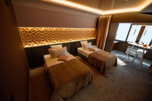ein Hotelzimmer mit 2 Betten und einem Tisch in der Unterkunft Апартаменты Радужный берег in Turksib