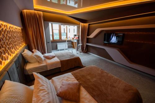 ein Hotelzimmer mit 2 Betten und einem TV in der Unterkunft Апартаменты Радужный берег in Turksib