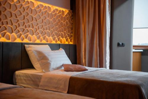 Schlafzimmer mit einem Bett mit einem großen Kopfteil in der Unterkunft Апартаменты Радужный берег in Turksib