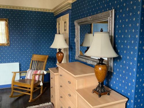 a room with a mirror and a lamp on a dresser at Rooms in City House nr Light Stadium in Sunderland