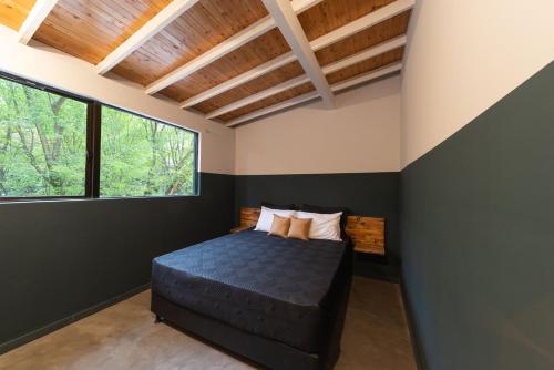 a bedroom with a bed and a window at Casa Mosaiko Patio Bonito in Medellín