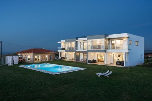 une grande maison avec une piscine dans la cour dans l'établissement SilverSide Holidays, à Caldas da Rainha