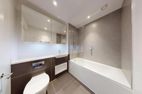 a bathroom with a toilet and a sink and a tub at City View 1 Bedroom Flat in London