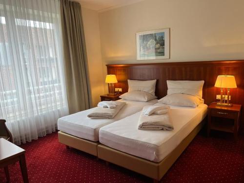 ein Hotelzimmer mit 2 Betten und 2 Lampen in der Unterkunft Hotel Hanseatischer Hof in Lübeck