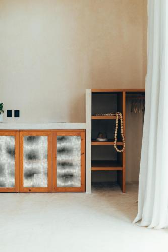 a room with a wooden cabinet and a curtain at Cucu Hotel El Cuyo in El Cuyo