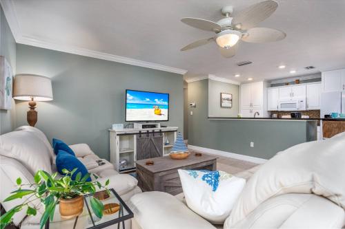 un soggiorno con mobili bianchi e TV a schermo piatto di Crystal Sands & Seahorses Beach Villa a Siesta Key